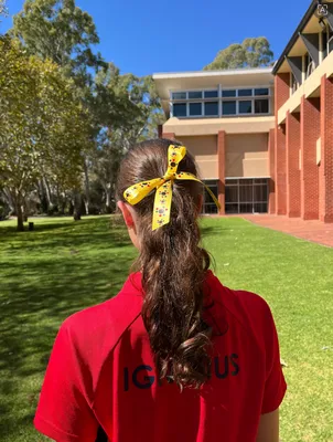 Double Face Satin Ribbon - Dani Kind from Saint Ignatius College Ribbon with a First Nations students art design for students at the College to wear during Reconciliation Week